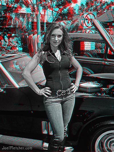Pretty woman poses in front of car.