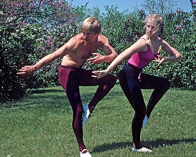 Dancers pose in a natural environment.
