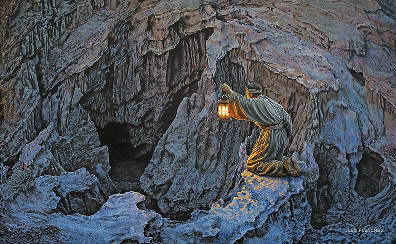 A man attempts to illuminate a mysterious cave with his lantern.